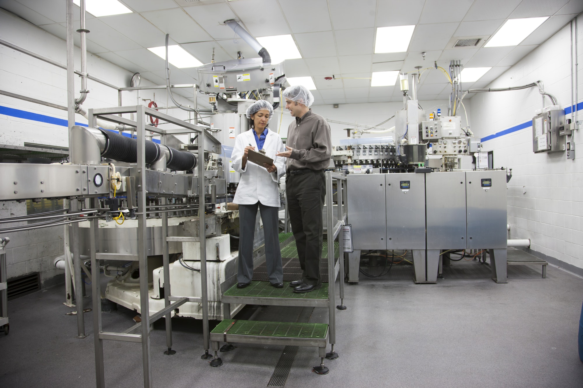 A discussion between a management person and a technician in a bottled water plant.